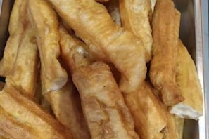 A tray of golden-brown fried dough sticks.