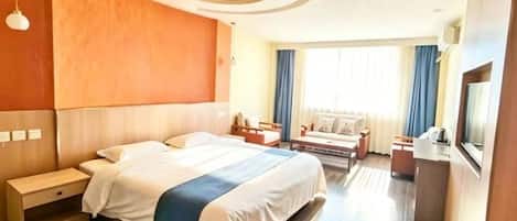A hotel room with a large bed, bedside tables, a desk, and a television.