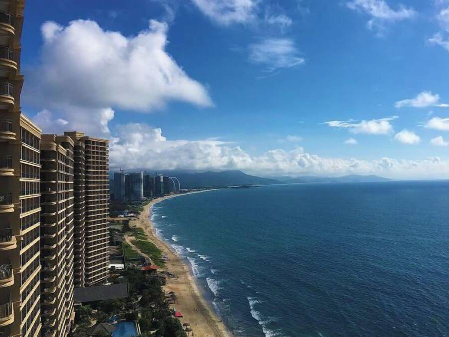 A coastal hotel with a view of the ocean and a beach.