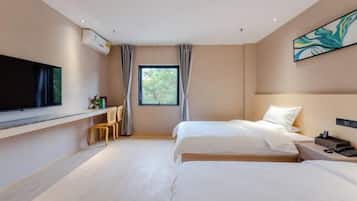A modern hotel room with a large bed, a TV, a desk, and a window with curtains.