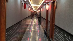 A hotel corridor with a reflective floor, wooden doors, and red lanterns. - Xinfanghua Hotel (Hejian Xinyulou Branch) (Hejian)
