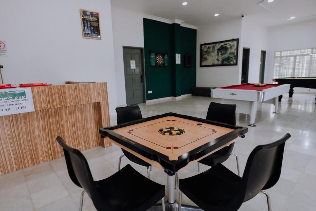 A room with a pool table, a foosball table, and a billiards table.