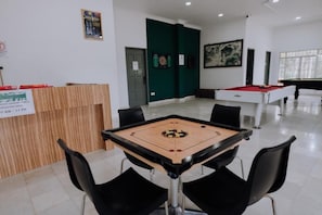 Una habitación con mesa de billar, mesa de fútbolín y mesa de pool.