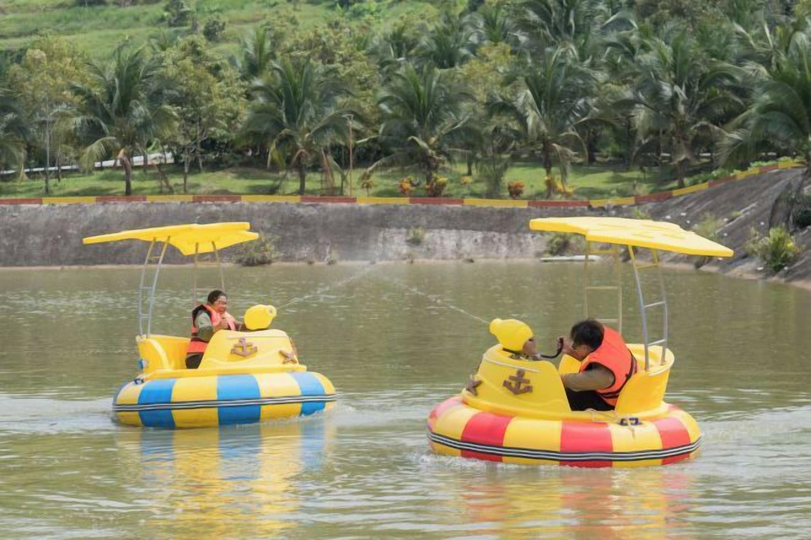 Two yellow watercraft with passengers, surrounded by water and palm trees.