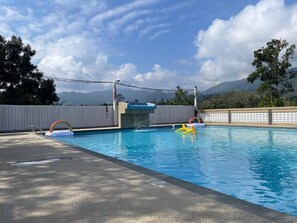 Una piscina con vista a las montañas al fondo.