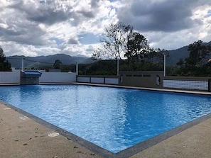 Una piscina con vistas a montañas al fondo.