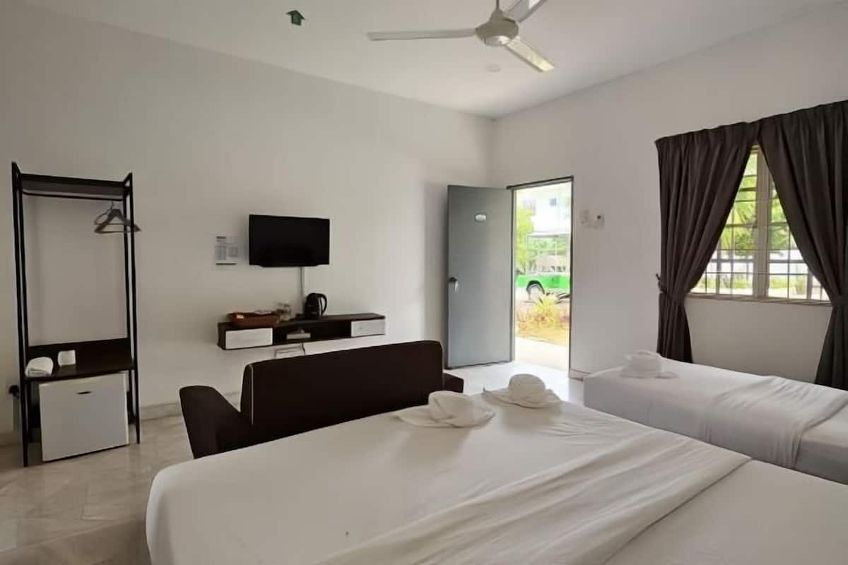 A hotel room with two beds, a desk with a chair, a television, and a wardrobe.