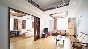 Une chambre d’hôtel équipée d’un lit, d’un bureau, d’un canapé, d’une télévision et d’une table basse.