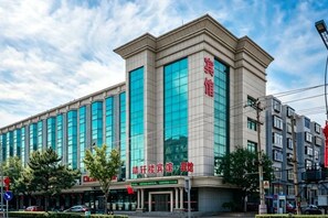 A multi-story building with large windows and signage indicating it is a hospital. - Jingxuanlou Hotel（near the great wall） (Qinhuangdao)