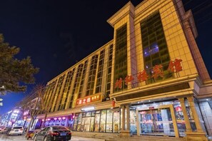 A hotel with a prominent entrance, multiple floors, and a large sign with Chinese characters. - Jingxuanlou Hotel(near the great wall) (Qinhuangdao)