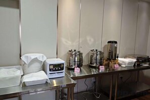 Una barra de desayuno con una máquina de café, tetras y una pila de servilletas.