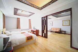 A hotel room with a bed, desk, chair, and a view of the outside.