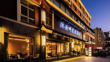 A hotel with a traditional architectural style, featuring multiple floors and a prominent signage.
