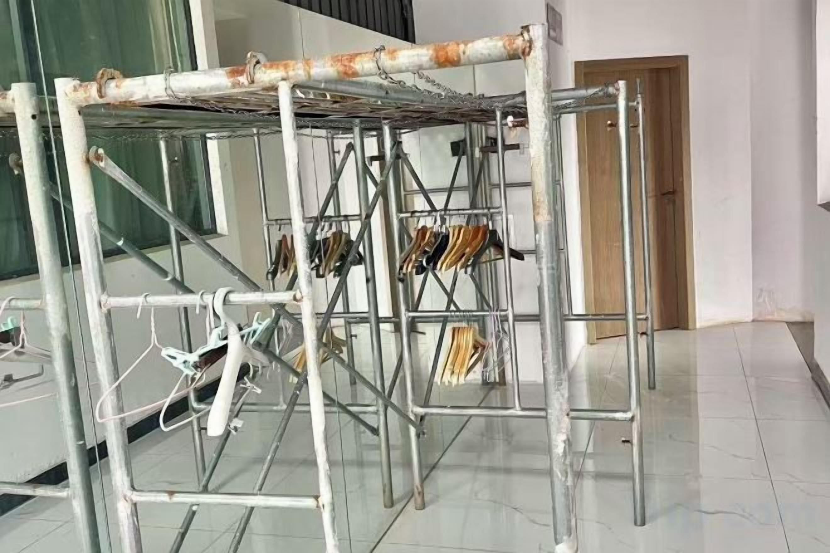A metal structure with a drying rack and hanging items, likely in a commercial or public space.