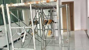 A metal structure with a drying rack and hanging items, likely in a commercial or public space.