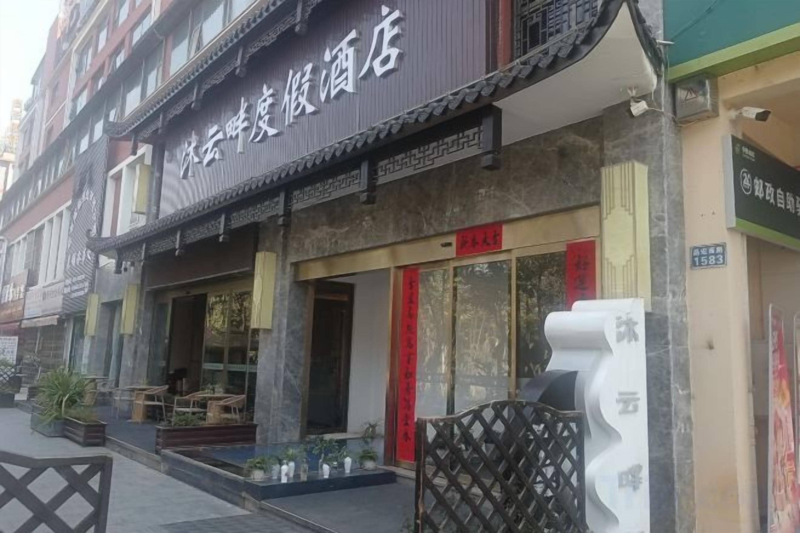A traditional building with a storefront, a red door, and a signboard.