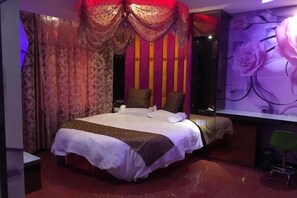 A bedroom with a large bed, curtains, a desk, and a chair. - Ai Jiu Hotel (Shanghai)