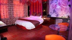 Een slaapkamer met een groot bed, een bureau en een stoel.