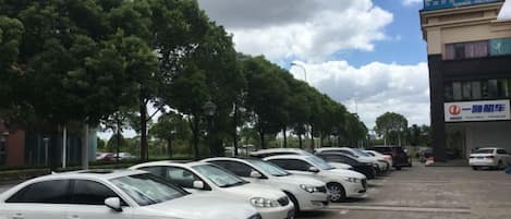 A row of parked cars in front of a building with a sign that reads '宾馆' (hotel).