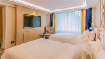 A hotel room with two beds, a TV, a chair, and a window with curtains.