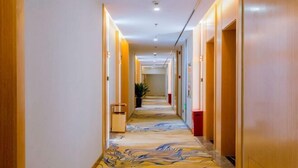 Un pasillo de hotel con piso de mármol y paredes de madera.