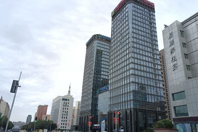 Un immeuble de grande hauteur doté d’une façade moderne en verre, de nombreux étages et d’une entrée imposante.