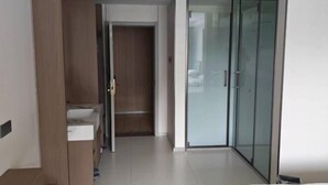 A modern hotel room with a glass door closet, a built-in sink, and a large bed. - Aketasi Resort (Nilka County)