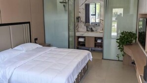 A modern hotel room with a bed, a shower, a vanity with a mirror, and a television. - Aketasi Resort (Nilka County)