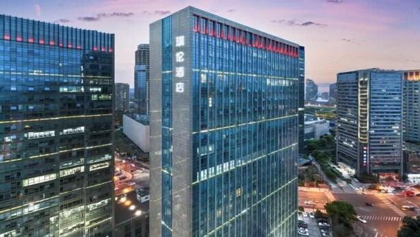 A modern high-rise building with reflective glass windows and a prominent sign. - Pulun Hotel (Shaoxing Didang Shimao Plaza) (Shaoxing)