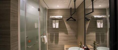A modern bathroom with a glass shower enclosure, two sinks with vessel basins, and a large mirror.