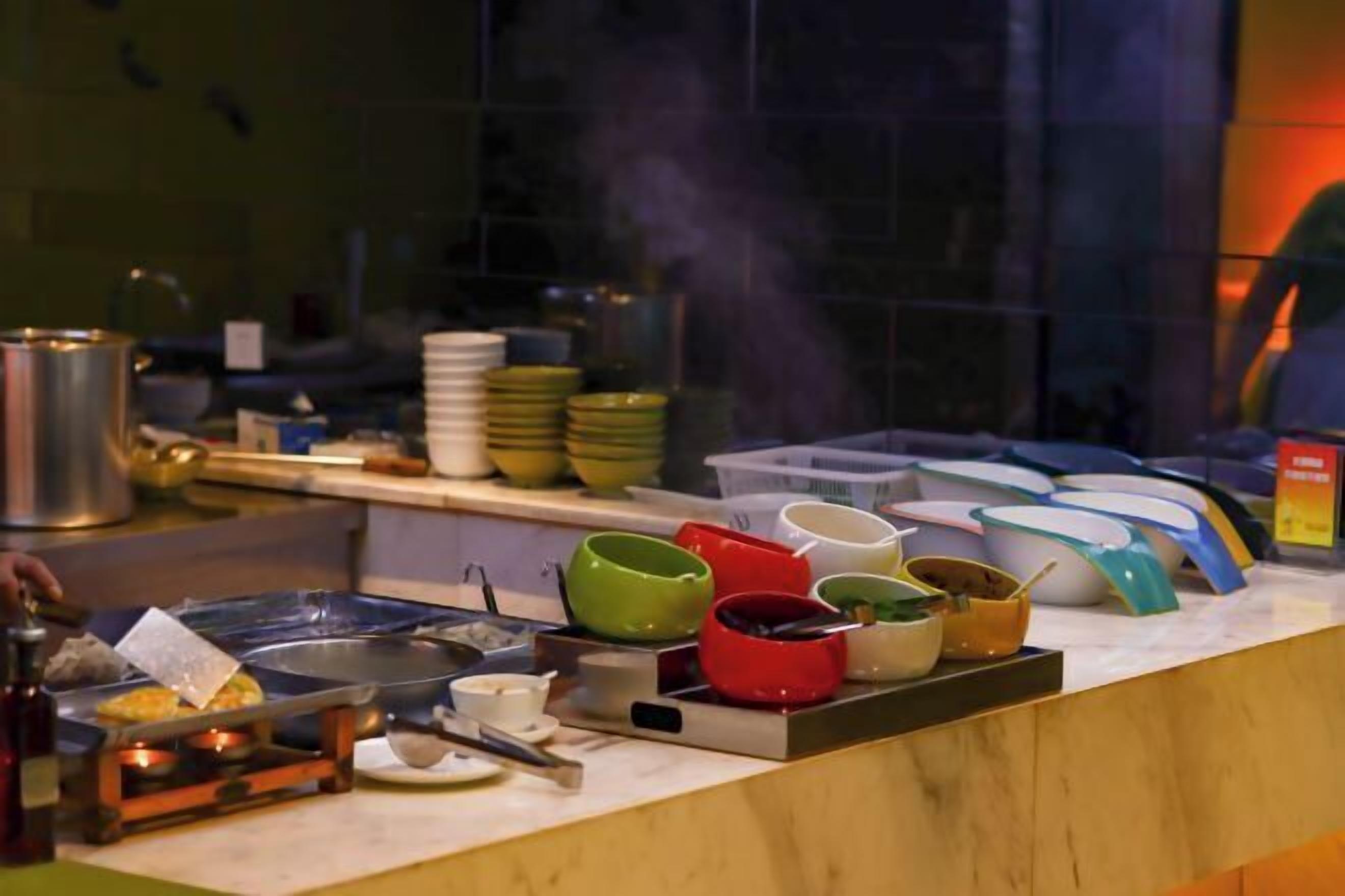 A buffet setup with various dishes and utensils.