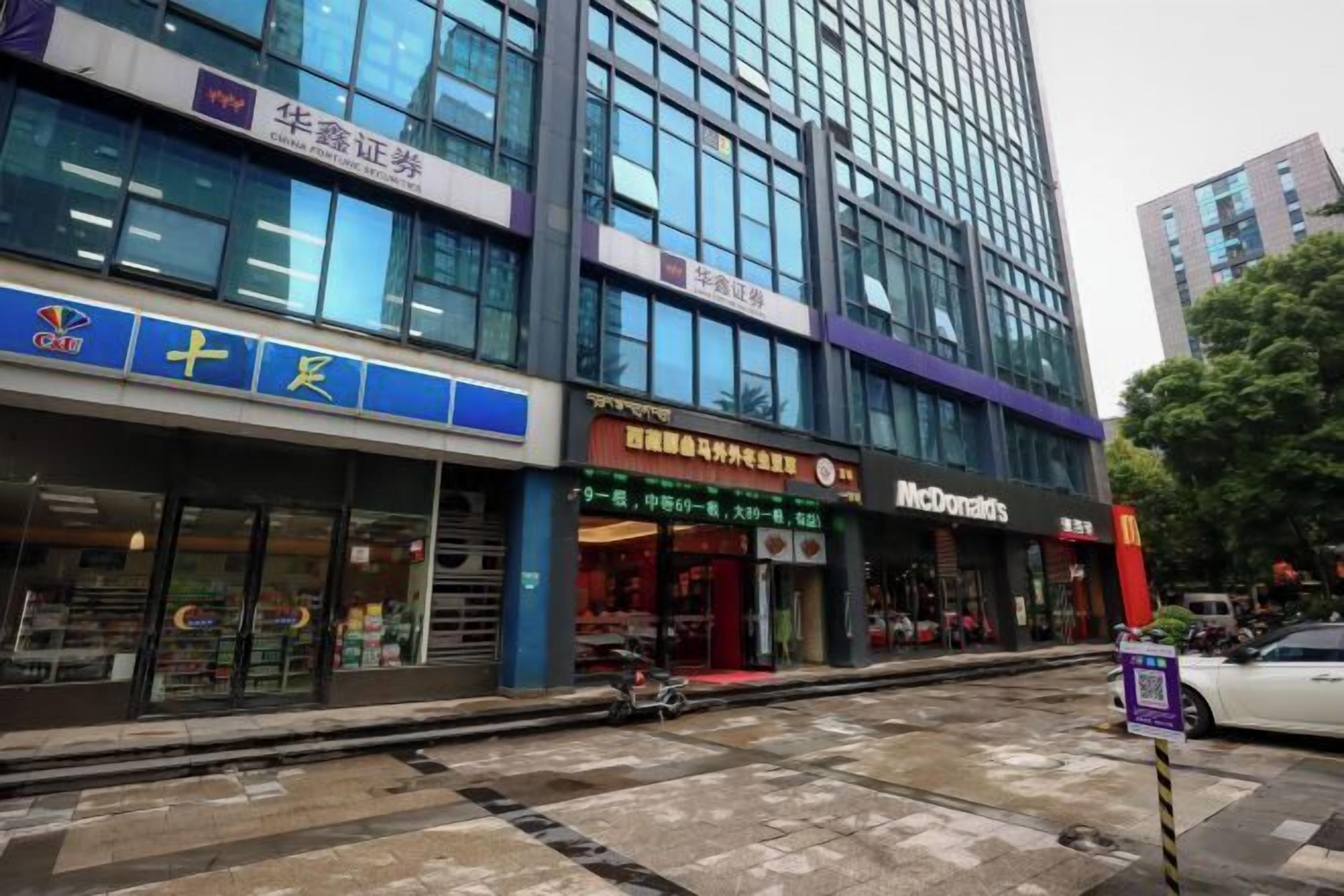 Un edificio moderno con varias tiendas, incluyendo McDonald's y una farmacia.