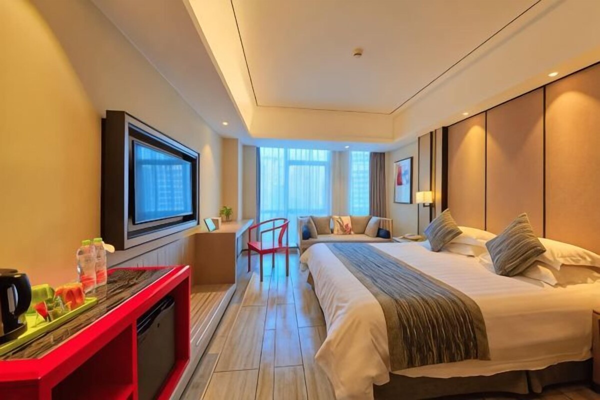 Une chambre d’hôtel avec un lit, une télévision, un bureau et une chaise.