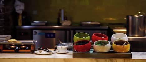 A kitchen counter with various bowls and a small dish rack.