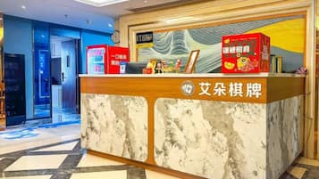 A reception desk with a marble top and a wooden frame, featuring a sign with Chinese characters and a red box with Chinese characters.