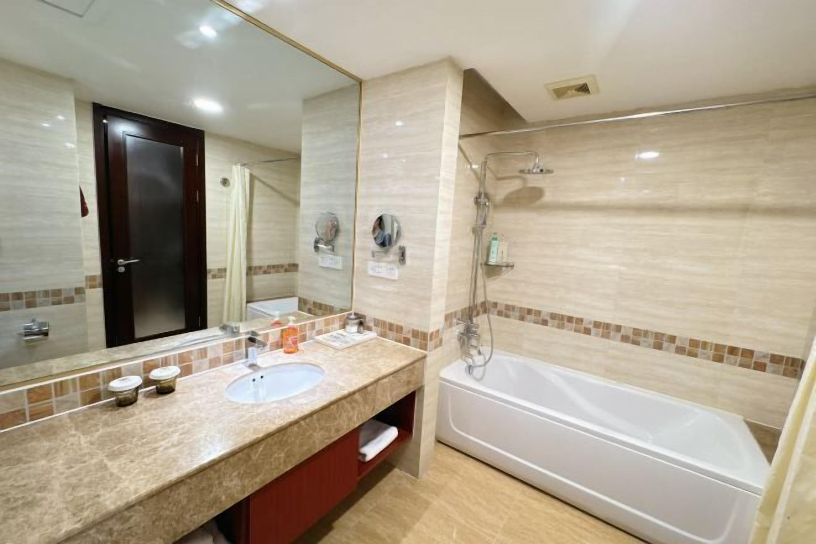 Une salle de bain avec un lavabo, un miroir et une baignoire.