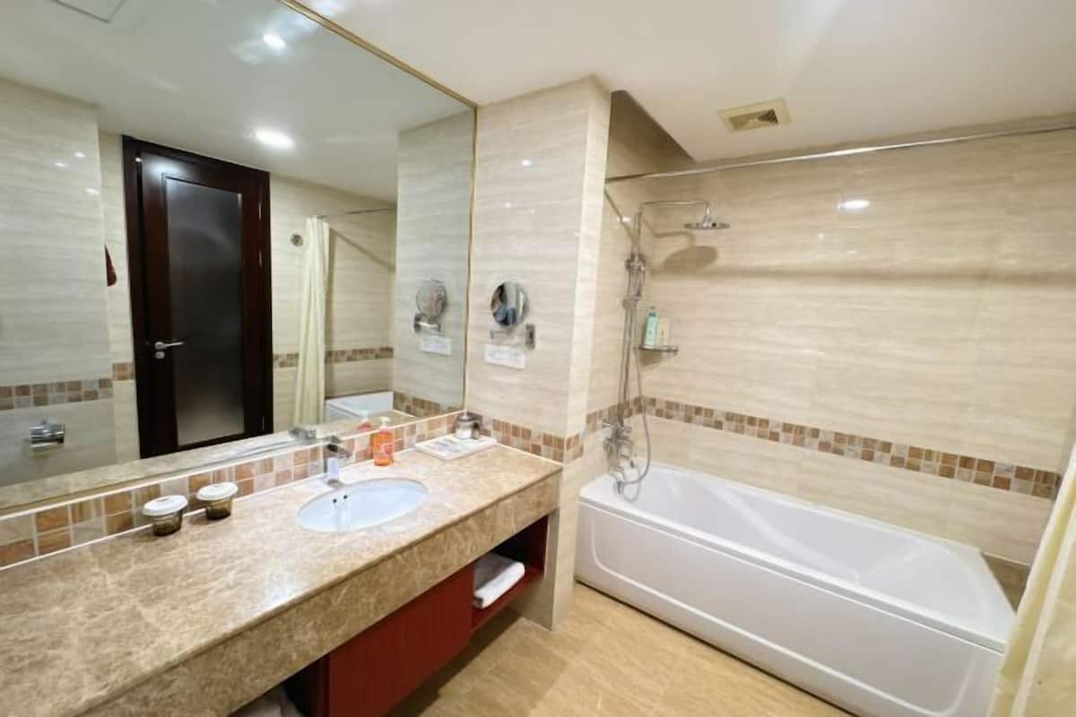 Une salle de bain avec un lavabo, un miroir et une baignoire.