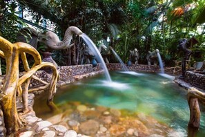 Un élément décoratif aquatique agrémenté de sculptures et d’un sentier en pierre.
