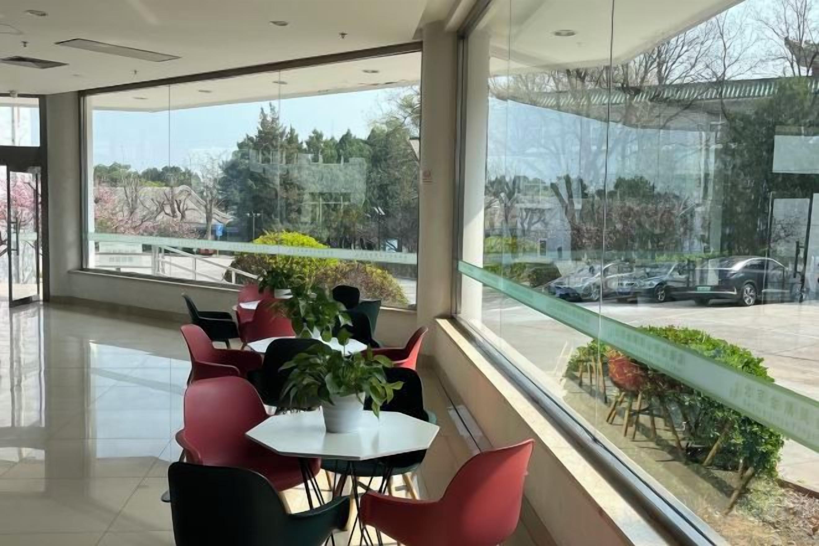 Un espace intérieur moderne doté d’un coin salon, de grandes fenêtres et d’une vue sur l’extérieur.