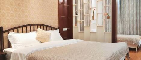 A bedroom with a large bed, a wooden headboard, a nightstand, and a built-in shelving unit with decorative items.