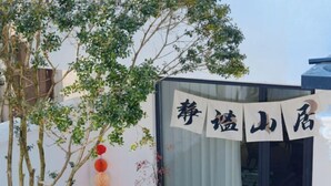 Un bâtiment orné d’une enseigne en caractères chinois, un arbre et une rangée de lanternes rouges.