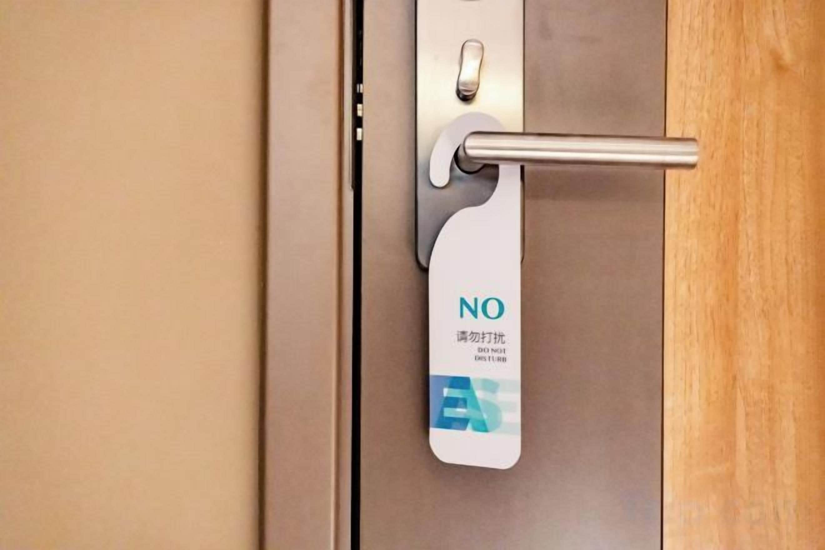 Uma porta com placa de 'Proibido Entrar' e maçaneta de metal.