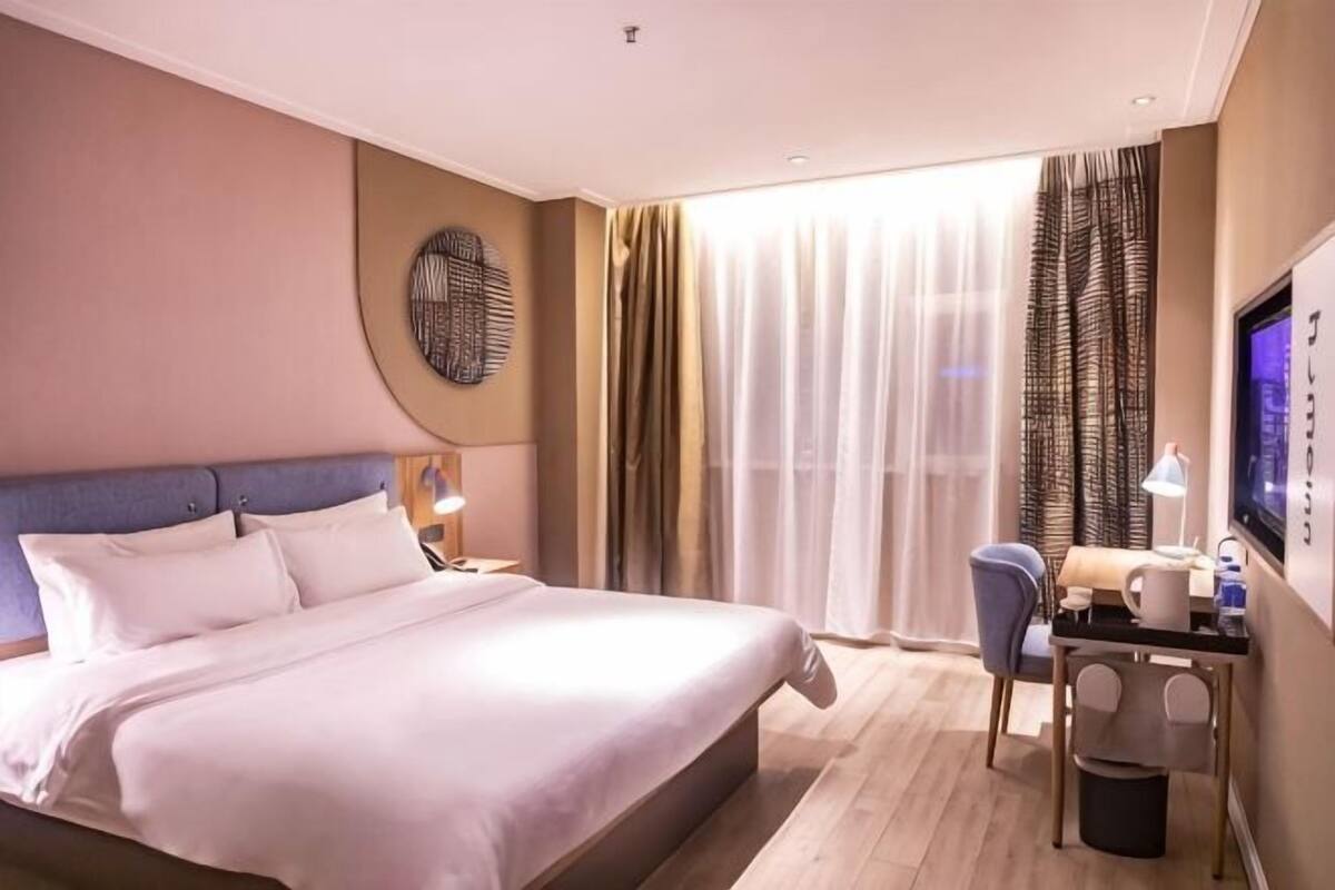 Une chambre d’hôtel équipée d’un lit, d’un bureau, d’une chaise et d’un téléviseur.