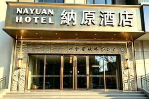 A hotel entrance with a sign reading 'NAYUAN HOTEL' and Chinese characters.