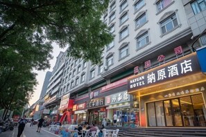 A hotel with a prominent sign, outdoor seating area, and a modern building facade. - Nayuan Hotel (A.D. Times City) (Taiyuan)