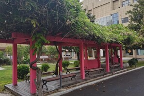 Un espacio de estar al aire libre cubierto con bancos y una estructura de pérgola.