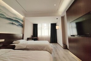 A hotel room with two beds, a TV, a painting on the wall, and a view of the room. - Zhengzhou Yindu Hotel (China Great Wall Aluminum) (Zhengzhou)