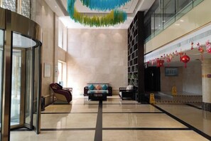 A hotel lobby with a glass partition, seating area, and a reception desk. - Zhengzhou Yindu Hotel (China Great Wall Aluminum) (Zhengzhou)