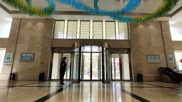 A hotel lobby with a revolving door, large windows, and a polished floor. - Zhengzhou Yindu Hotel (China Great Wall Aluminum) (Zhengzhou)