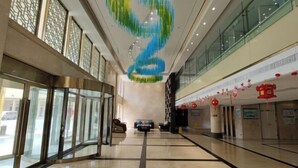A spacious lobby with a central spiral staircase, glass railings, and a modern ceiling design. - Zhengzhou Yindu Hotel (China Great Wall Aluminum) (Zhengzhou)